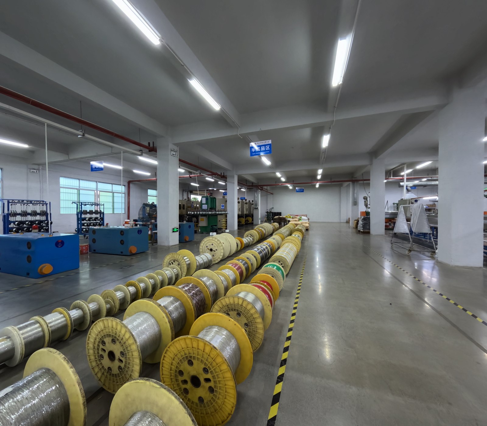 Semi-finished cable reels arranged between production stages